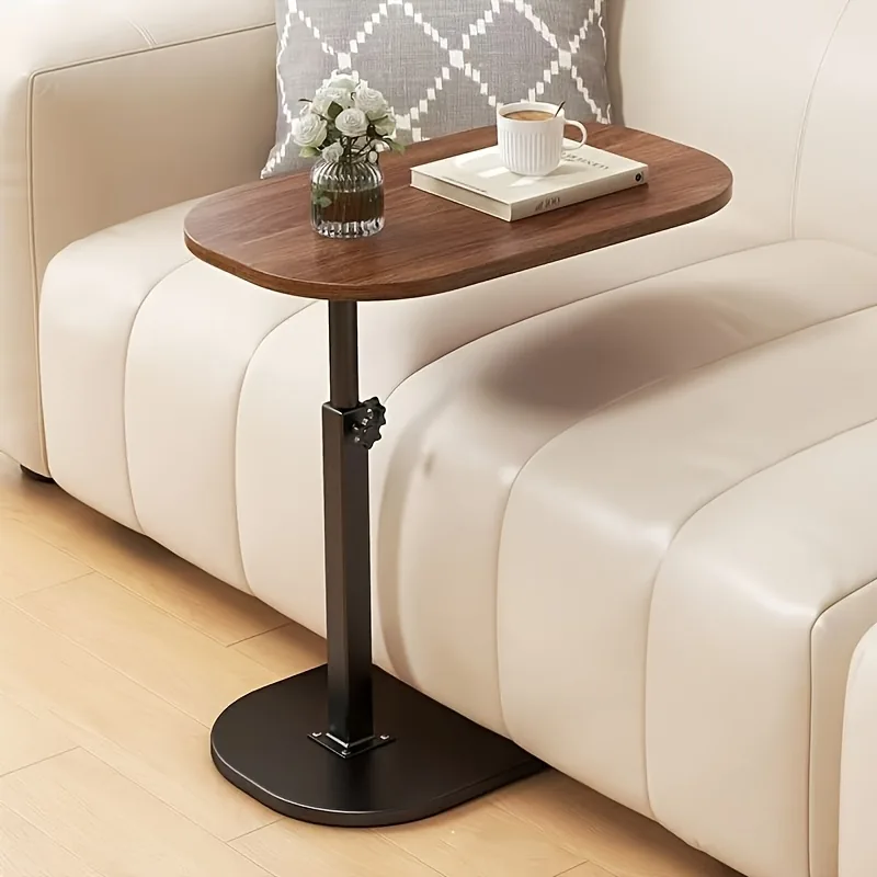 Table d'appoint Hotori, plateau ovale noyer sur pied noir, glissée contre un canapé crème